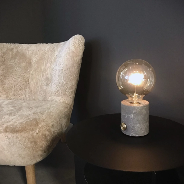 Hyggelig belysning med tr�dl�s marmorlampe ved l�nestol &ndash; genopladelig bordlampe i dansk design, der skaber stemning i stuen i op til 24 timer.
